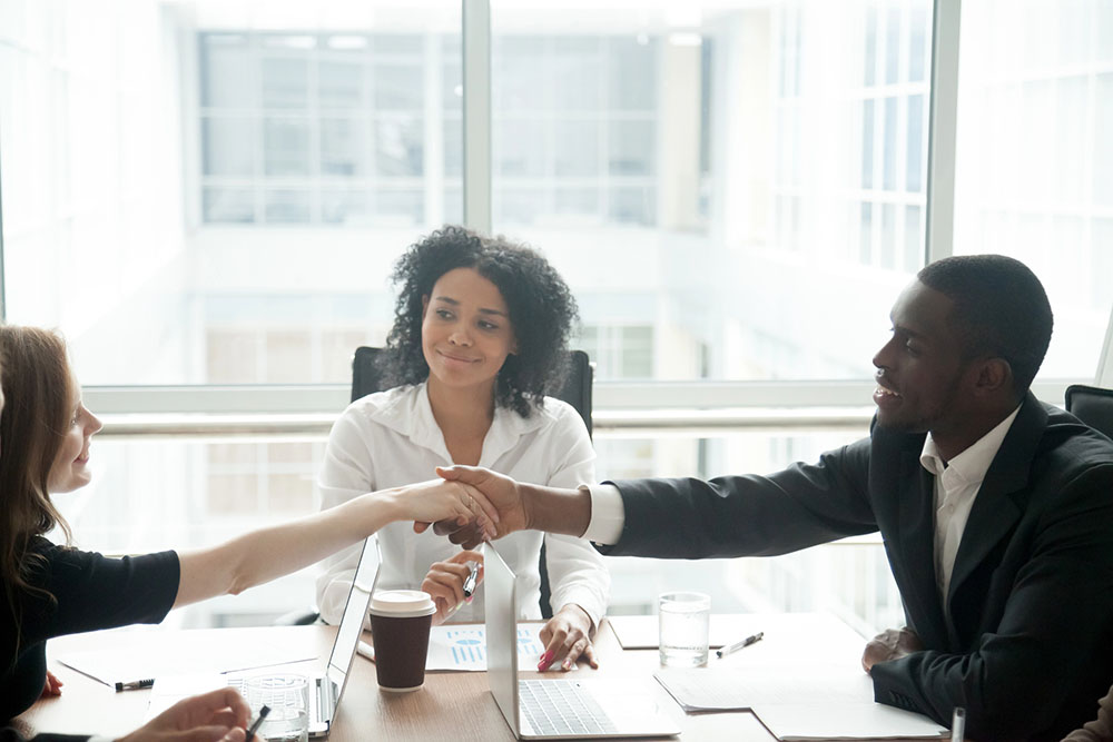 Smiling african businessman handshaking greeting caucasian busin